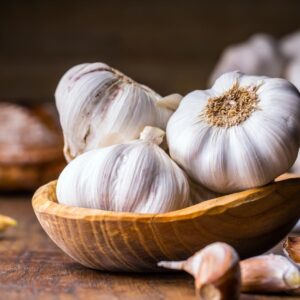 garlic,cloves,and,bulb,in,vintage,wooden,bowl.
